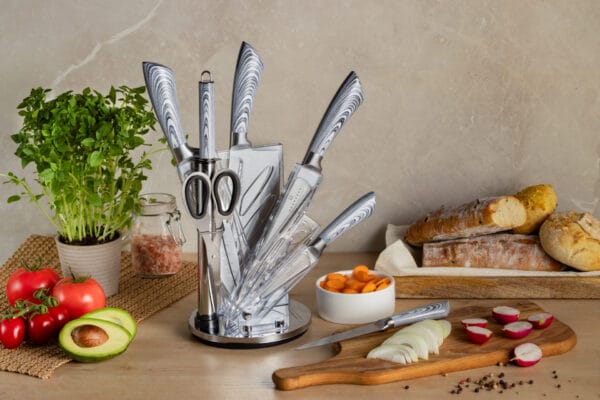 Zestaw noży kuchennych ze stojakiem Edenberg EB-914 w eleganckim akrylowym stojaku z chromowanym wykończeniem. W skład zestawu wchodzą noże szefa kuchni, do chleba, uniwersalny, do obierania, do siekania oraz nożyczki kuchenne.